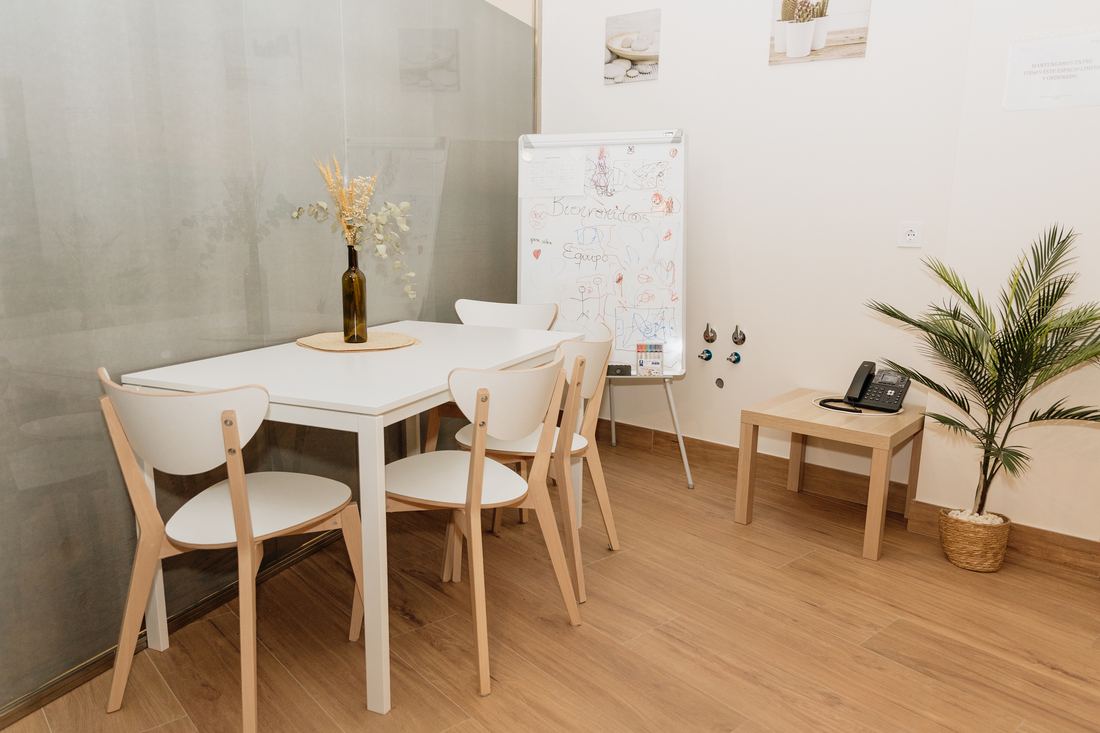 Sala de reuniones de Espacio Vidda con mesa blanca y sillas de madera